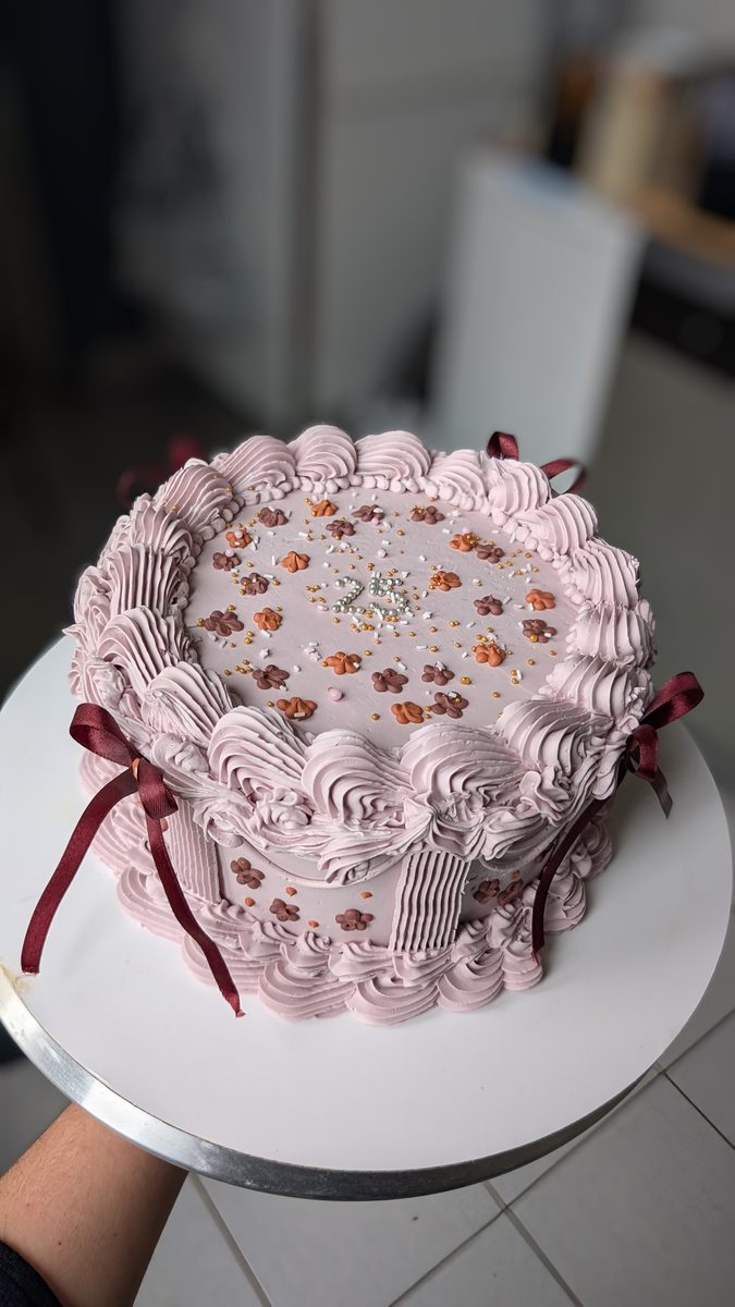 Gâteau d'anniversaire rose décoré à la poche à douille